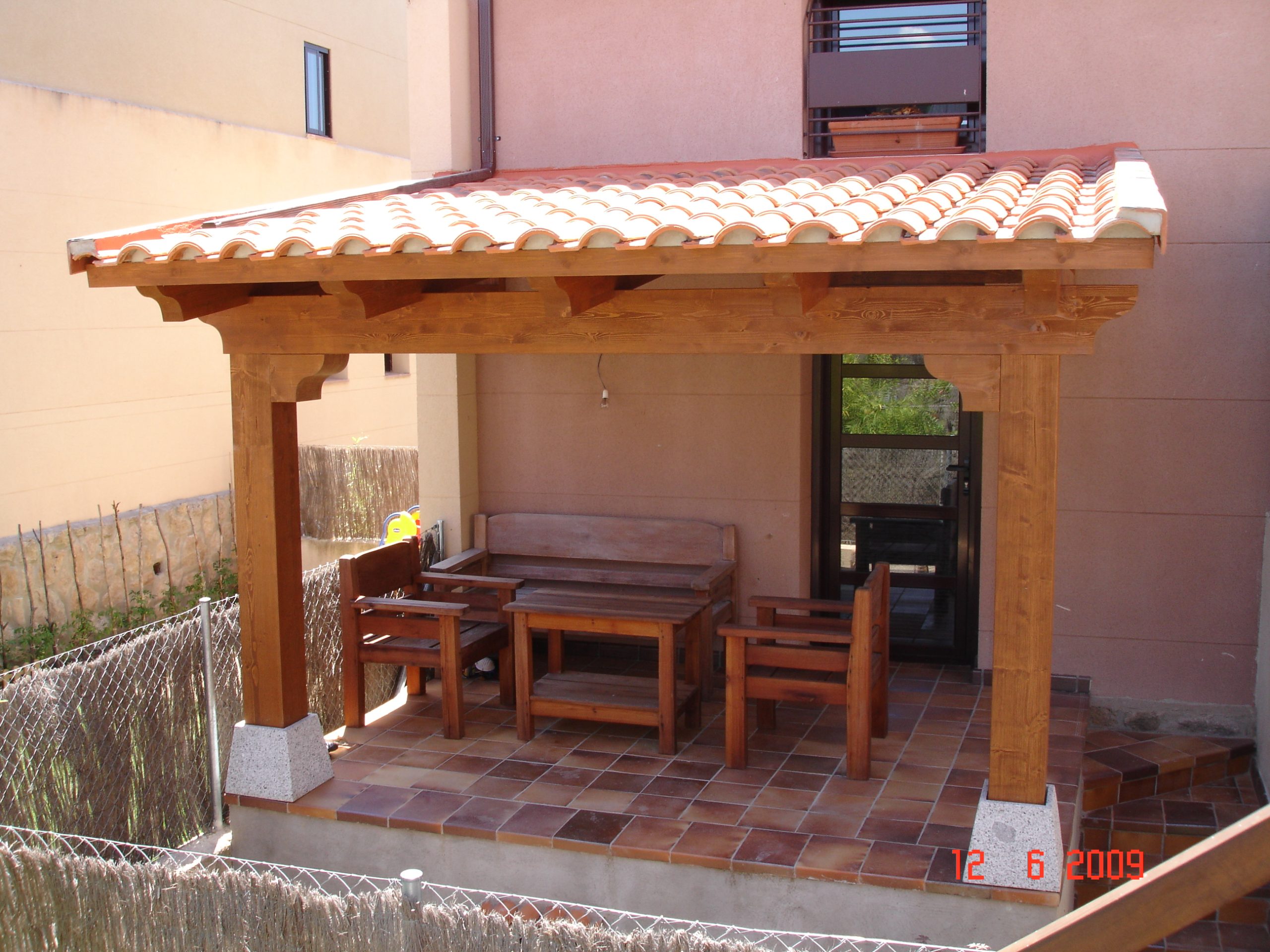 Porche de madera con cubierta de teja y zona de descanso